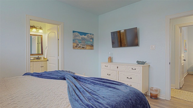 923 Tidelands Dr, Galveston, TX 77650 - bedroom with light wood-style floors, baseboards, and ensuite bath