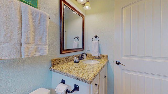 923 Tidelands Dr, Galveston, TX 77650 - bathroom featuring vanity, a textured wall, and toilet