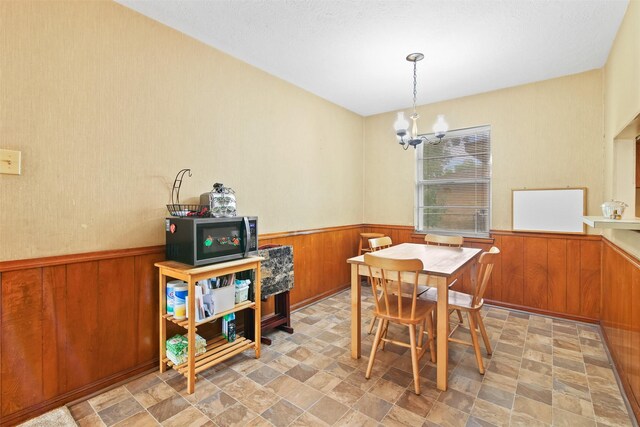 16203 White Star Dr, Houston, TX 77062 - dining area with wainscoting, wood walls, a chandelier, and stone finish floors