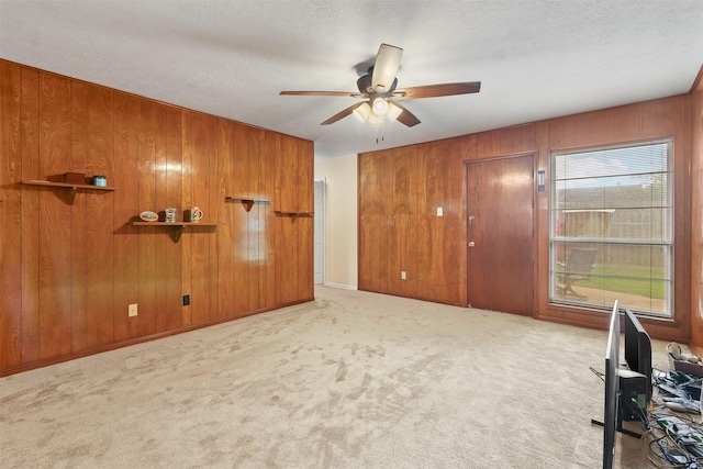 16203 White Star Dr, Houston, TX 77062 - unfurnished living room featuring wooden walls, a ceiling fan, carpet, and a textured ceiling