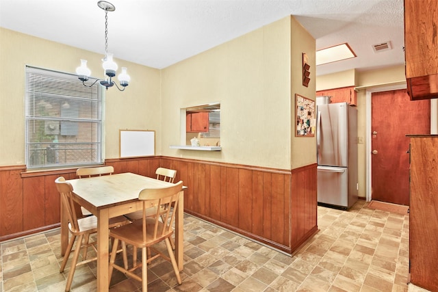 16203 White Star Dr, Houston, TX 77062 - dining space with wood walls, wainscoting, a chandelier, and stone finish floors