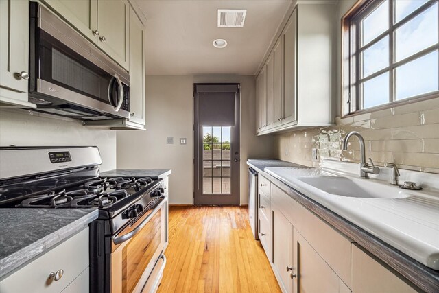 808 Coronado St, Houston, TX 77009 - kitchen with appliances with stainless steel finishes, tasteful backsplash, light wood finished floors, a sink, and recessed lighting