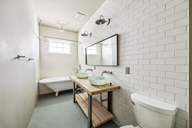 808 Coronado St, Houston, TX 77009 - bathroom with toilet, double vanity, tile walls, and a combined bath / shower with freestanding tub