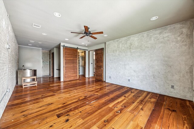 808 Coronado St, Houston, TX 77009 - unfurnished living room featuring ceiling fan, a barn door, wood-type flooring, and recessed lighting