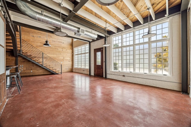 808 Coronado St, Houston, TX 77009 - unfurnished living room with concrete flooring, wooden walls, beamed ceiling, and stairway