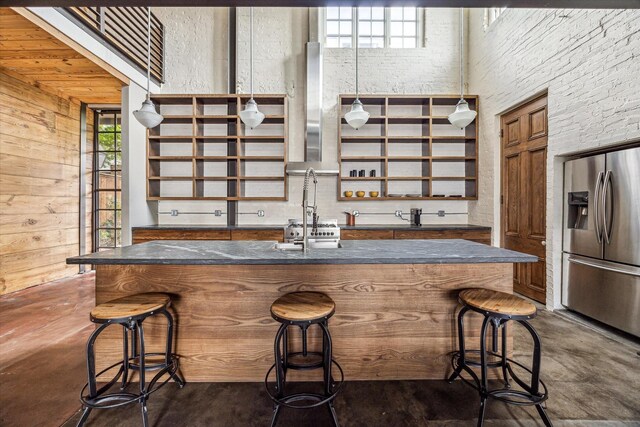 808 Coronado St, Houston, TX 77009 - kitchen featuring stainless steel fridge with ice dispenser, finished concrete floors, a breakfast bar, open shelves, and wood walls