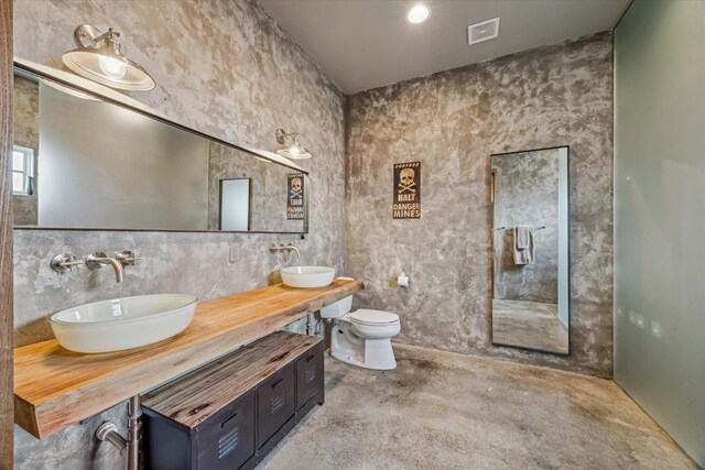 808 Coronado St, Houston, TX 77009 - full bathroom with double vanity, toilet, and concrete flooring