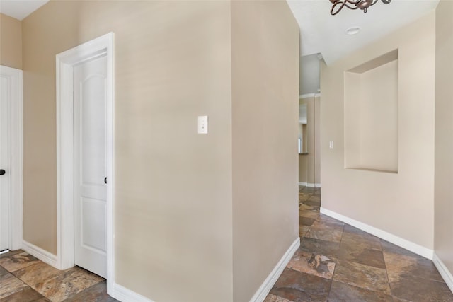 1511 Tournament Ct, Crosby, TX 77532 - corridor with stone tile floors, baseboards, and a chandelier
