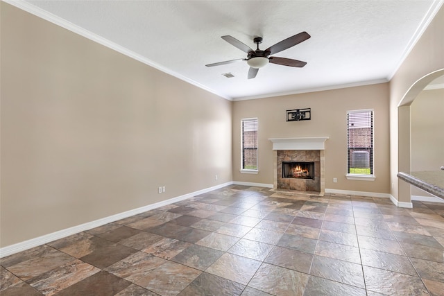 1511 Tournament Ct, Crosby, TX 77532 - unfurnished living room featuring stone tile floors, baseboards, a fireplace, a ceiling fan, and ornamental molding