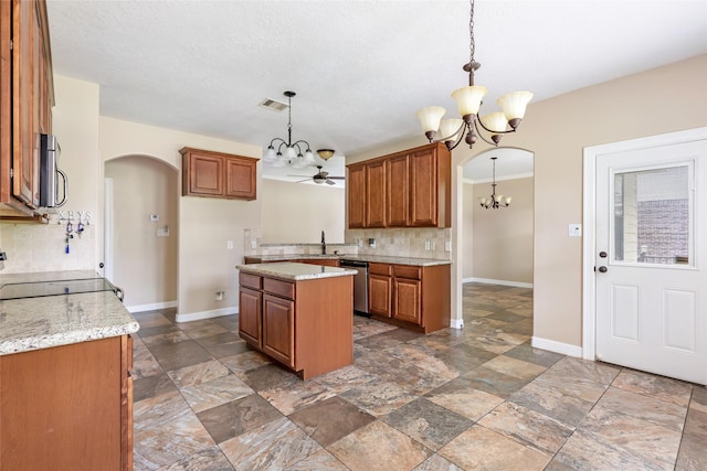 1511 Tournament Ct, Crosby, TX 77532 - kitchen with a chandelier, brown cabinets, arched walkways, and tasteful backsplash