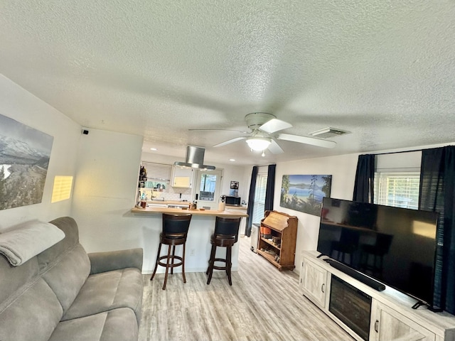 11837 13th St, Santa Fe, TX 77510 - living room with light wood finished floors, a ceiling fan, and a textured ceiling