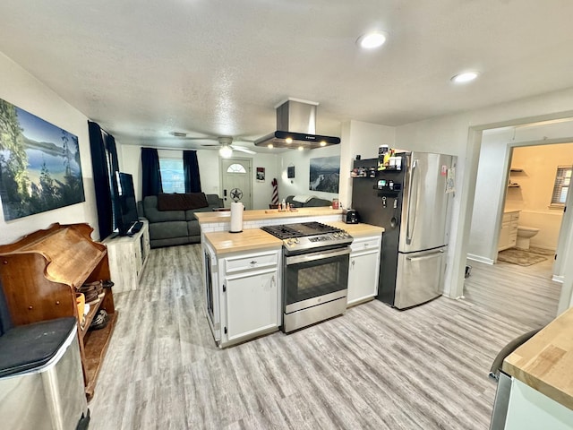 11837 13th St, Santa Fe, TX 77510 - kitchen featuring appliances with stainless steel finishes, island exhaust hood, light wood-type flooring, a peninsula, and white cabinetry