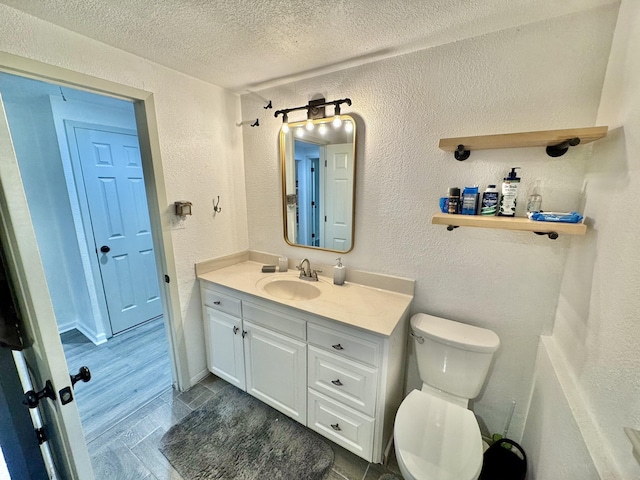 11837 13th St, Santa Fe, TX 77510 - bathroom featuring toilet, a textured wall, vanity, a textured ceiling, and wood finished floors