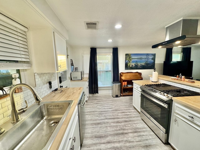 11837 13th St, Santa Fe, TX 77510 - kitchen featuring a sink, stainless steel appliances, wooden counters, white cabinets, and recessed lighting
