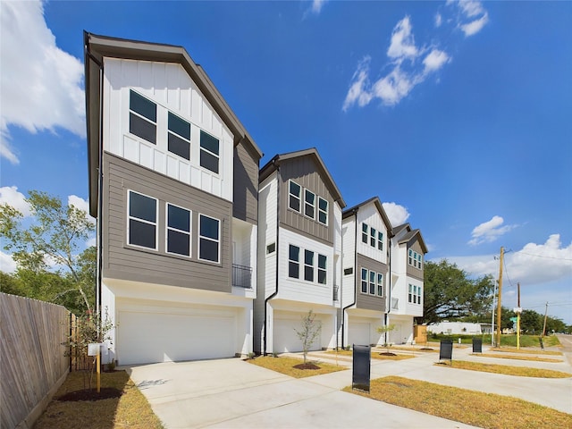 6834 Lozier St, Houston, TX 77021 - view of front of house featuring board and batten siding, an attached garage, driveway, and a residential view