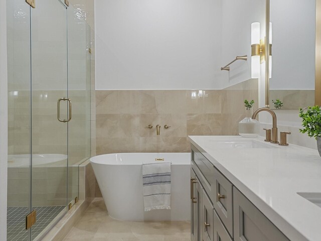5016 Golden Forest Dr, Houston, TX 77091 - full bathroom with tile walls, double vanity, a stall shower, a soaking tub, and tile patterned flooring