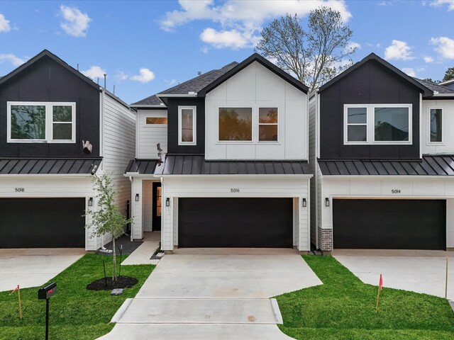 5016 Golden Forest Dr, Houston, TX 77091 - view of front facade with a standing seam roof, an attached garage, driveway, and metal roof