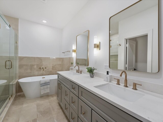 5016 Golden Forest Dr, Houston, TX 77091 - full bathroom with double vanity, a freestanding bath, a stall shower, and tile walls