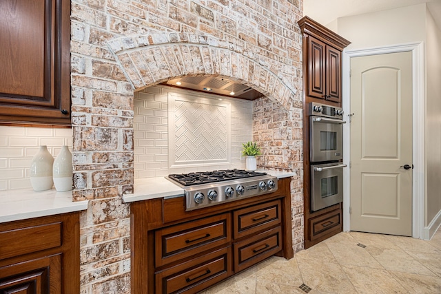 24914 Misty Heath Ln, Katy, TX 77494 - kitchen featuring appliances with stainless steel finishes, backsplash, light tile patterned floors, and arched walkways