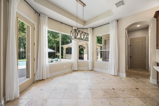 24914 Misty Heath Ln, Katy, TX 77494 - unfurnished dining area with baseboards, arched walkways, and a tray ceiling