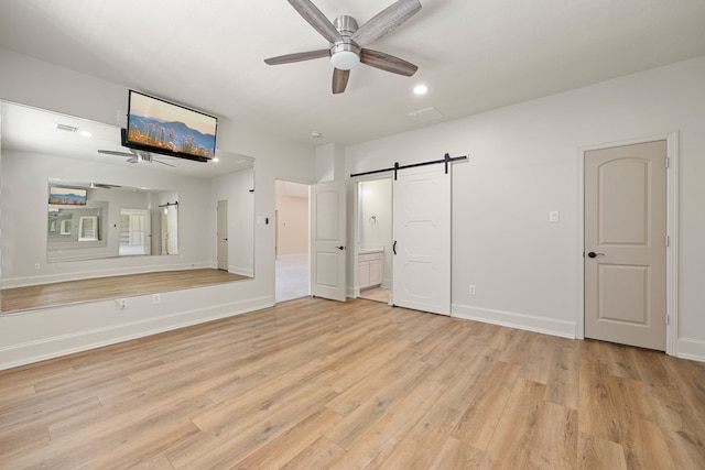 24914 Misty Heath Ln, Katy, TX 77494 - unfurnished bedroom with a barn door, light wood finished floors, baseboards, ensuite bath, and recessed lighting