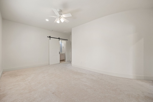 24914 Misty Heath Ln, Katy, TX 77494 - spare room with light colored carpet, baseboards, a ceiling fan, and a barn door