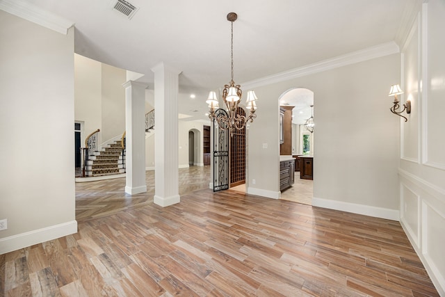 24914 Misty Heath Ln, Katy, TX 77494 - spare room with arched walkways, a chandelier, light wood-style floors, stairway, and crown molding
