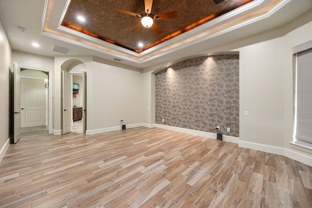 24914 Misty Heath Ln, Katy, TX 77494 - spare room with a raised ceiling, a ceiling fan, arched walkways, baseboards, and light wood-style flooring