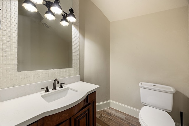 24914 Misty Heath Ln, Katy, TX 77494 - bathroom featuring toilet, vanity, wood finished floors, baseboards, and lofted ceiling