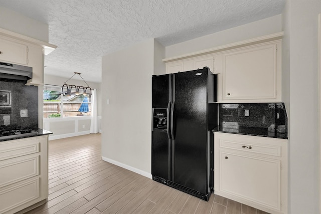 6606 Chancellor Dr, Spring, TX 77379 - kitchen featuring black fridge with ice dispenser, decorative backsplash, gas stovetop, baseboards, and a textured ceiling