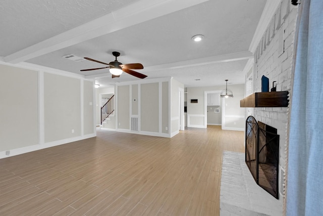 6606 Chancellor Dr, Spring, TX 77379 - unfurnished living room with a brick fireplace, a ceiling fan, light wood finished floors, stairway, and baseboards