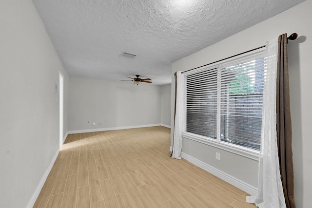 6606 Chancellor Dr, Spring, TX 77379 - spare room with a ceiling fan, a textured ceiling, baseboards, and light wood-style flooring