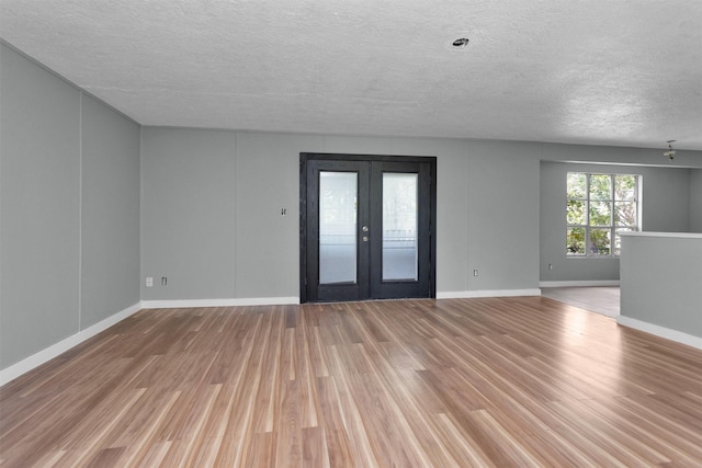 4909 Falls St, Houston, TX 77026 - unfurnished room with a textured ceiling, wood finished floors, french doors, and baseboards