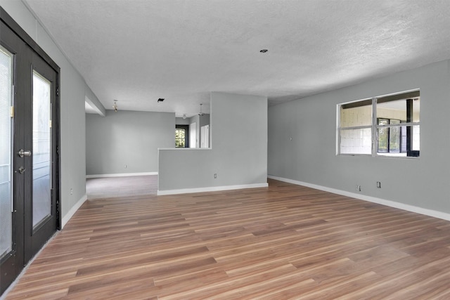 4909 Falls St, Houston, TX 77026 - spare room with a textured ceiling, light wood-style flooring, and baseboards