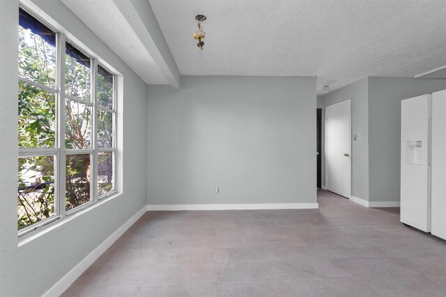 4909 Falls St, Houston, TX 77026 - empty room featuring healthy amount of natural light, baseboards, and a textured ceiling