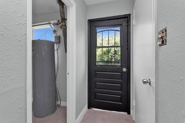 4909 Falls St, Houston, TX 77026 - entryway featuring water heater, a textured wall, and baseboards