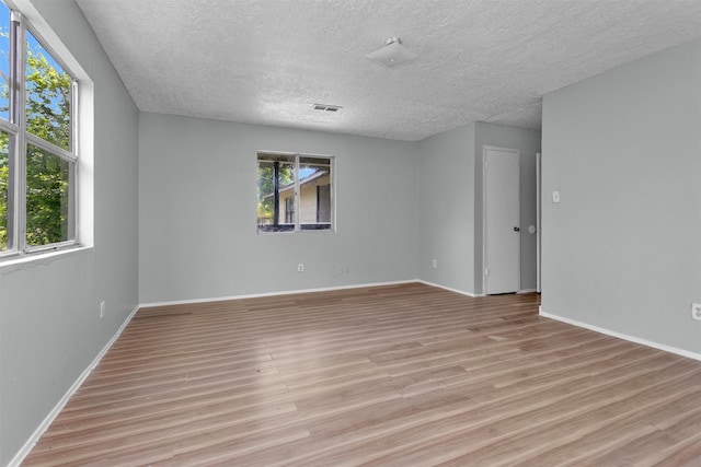 4909 Falls St, Houston, TX 77026 - spare room with a textured ceiling, light wood finished floors, and baseboards