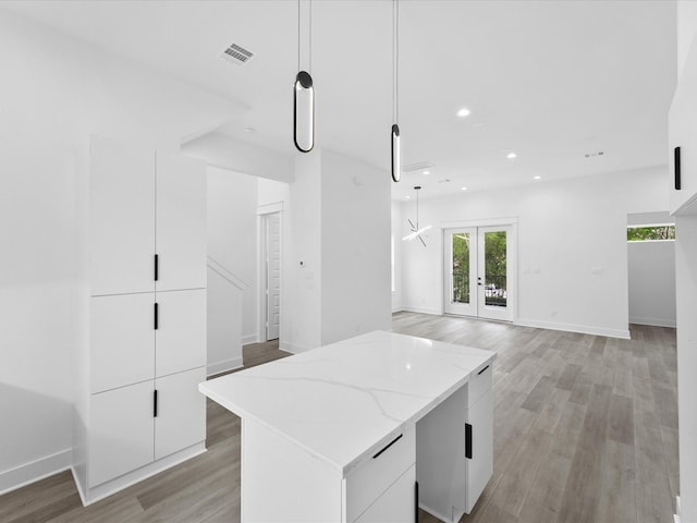 1266-1264 Finnigan St, Houston, TX 77020 - kitchen with modern cabinets, light wood-style floors, white cabinets, light stone counters, and pendant lighting
