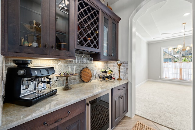 1003 Angel Forest Ct, Pinehurst, TX 77362 - indoor dry bar with beverage cooler, backsplash, light carpet, arched walkways, and a chandelier