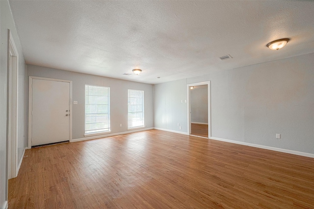 5619 Willow Glen Dr, Houston, TX 77033 - spare room featuring a textured ceiling, wood finished floors, and baseboards