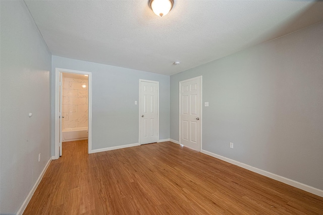 5619 Willow Glen Dr, Houston, TX 77033 - unfurnished bedroom featuring wood finished floors, baseboards, and ensuite bathroom