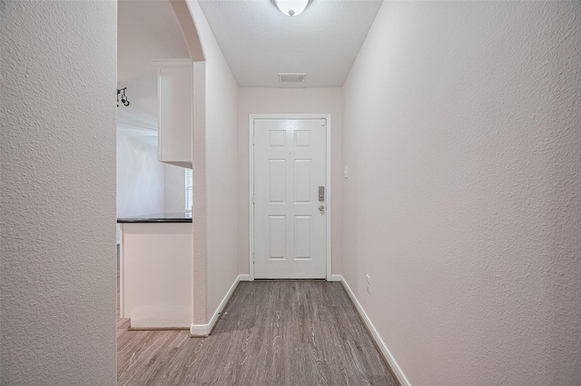 28861 Llano River Loop, Spring, TX 77386 - corridor featuring wood finished floors, baseboards, a textured wall, and arched walkways