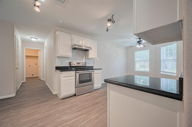 28861 Llano River Loop, Spring, TX 77386 - kitchen with stainless steel electric range oven, under cabinet range hood, dark countertops, white cabinets, and light wood-style floors