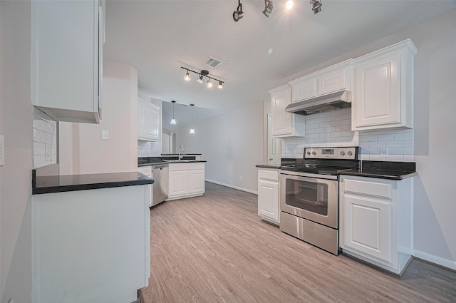 28861 Llano River Loop, Spring, TX 77386 - kitchen featuring stainless steel appliances, under cabinet range hood, white cabinetry, tasteful backsplash, and baseboards