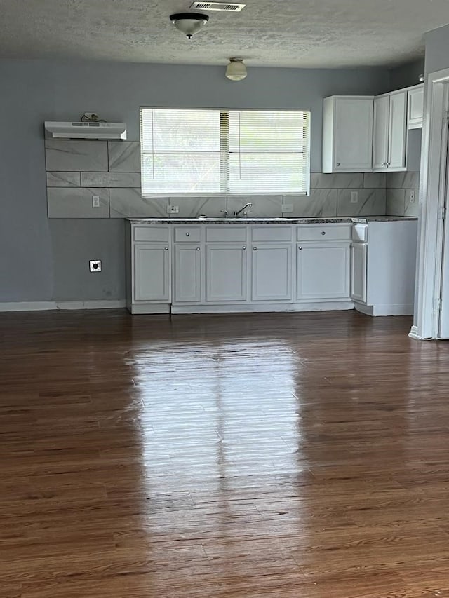 6058 Glenhurst Dr, Houston, TX 77033 - kitchen with dark wood-type flooring, white cabinetry, a textured ceiling, decorative backsplash, and open shelves