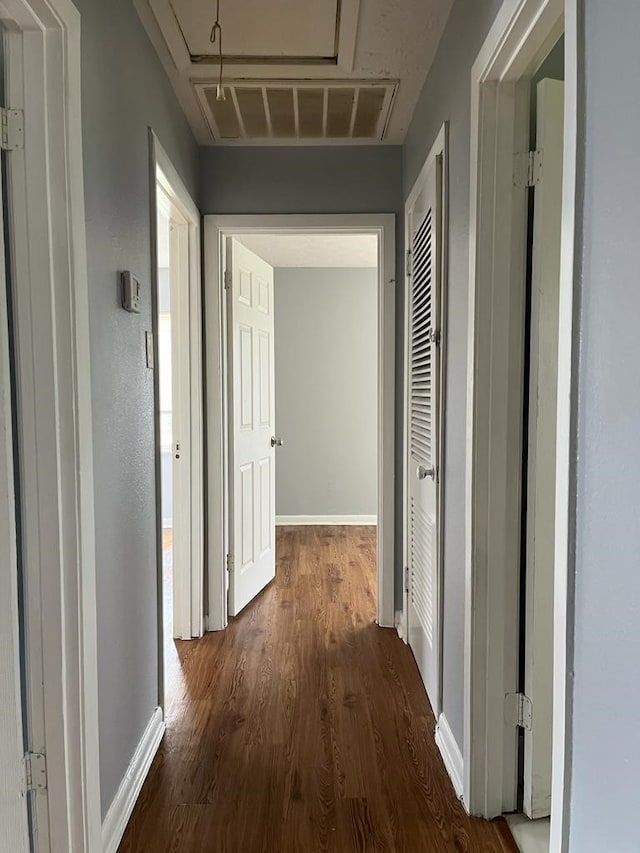 6058 Glenhurst Dr, Houston, TX 77033 - corridor with attic access, dark wood-style flooring, and baseboards