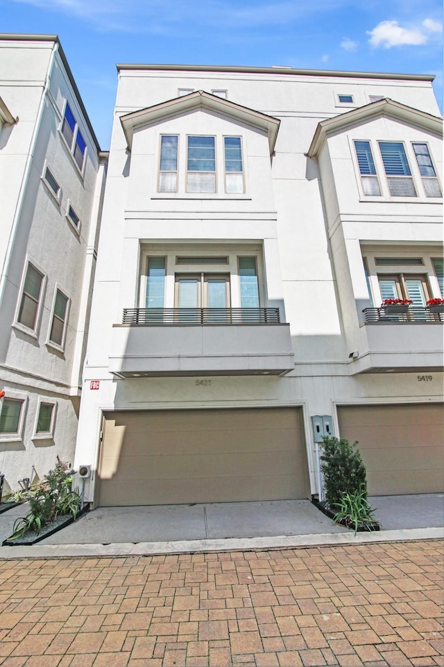 5421 Larkin St, Houston, TX 77007 - view of front of property with stucco siding, a garage, and decorative driveway