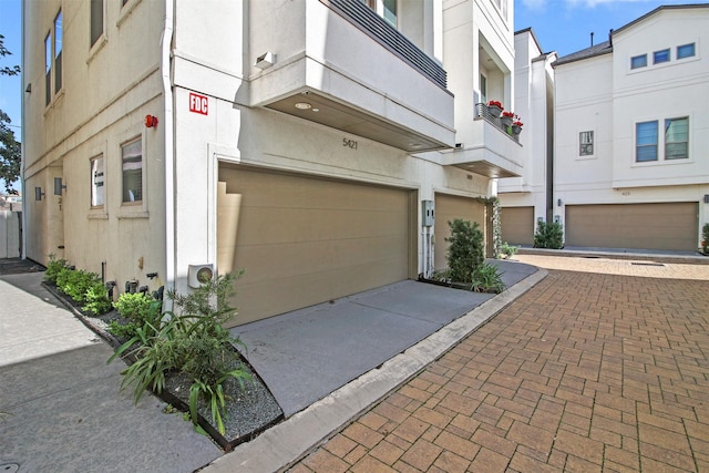 5421 Larkin St, Houston, TX 77007 - view of side of home featuring an attached garage, driveway, and stucco siding