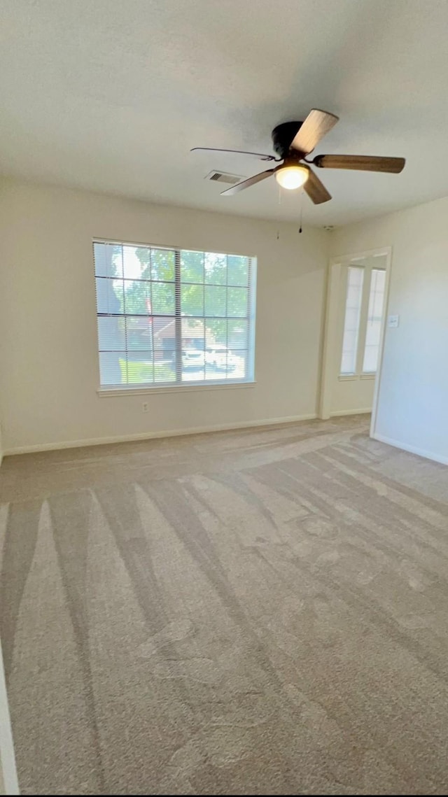 9827 Westminster Dr, Humble, TX 77338 - unfurnished room with baseboards, healthy amount of natural light, ceiling fan, and light colored carpet