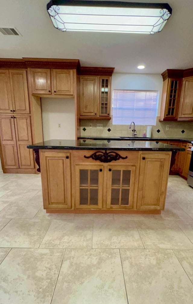 9827 Westminster Dr, Humble, TX 77338 - kitchen with tasteful backsplash, glass insert cabinets, brown cabinetry, and stainless steel stove